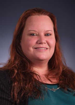 Alicia Frasher smiling wearing a green and black shirt