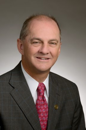 Barry Hickey smiling in a grey suit