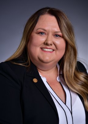 Kristy Napier smiling in a black and white suit