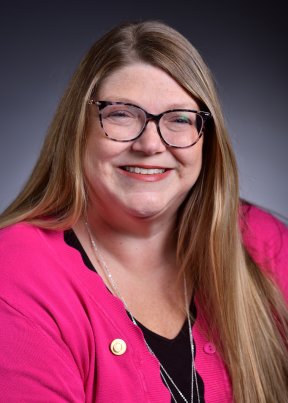 Laura Owens smiling in a pink and black suit