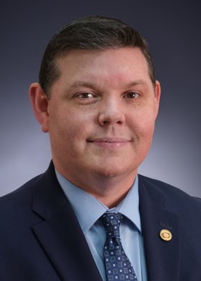 Clayton rogers smiling in a blue suit