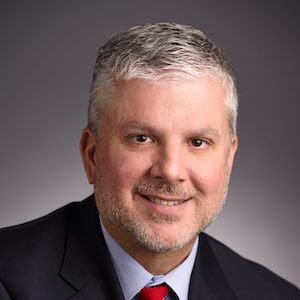 Todd Addington smiling in a black suit